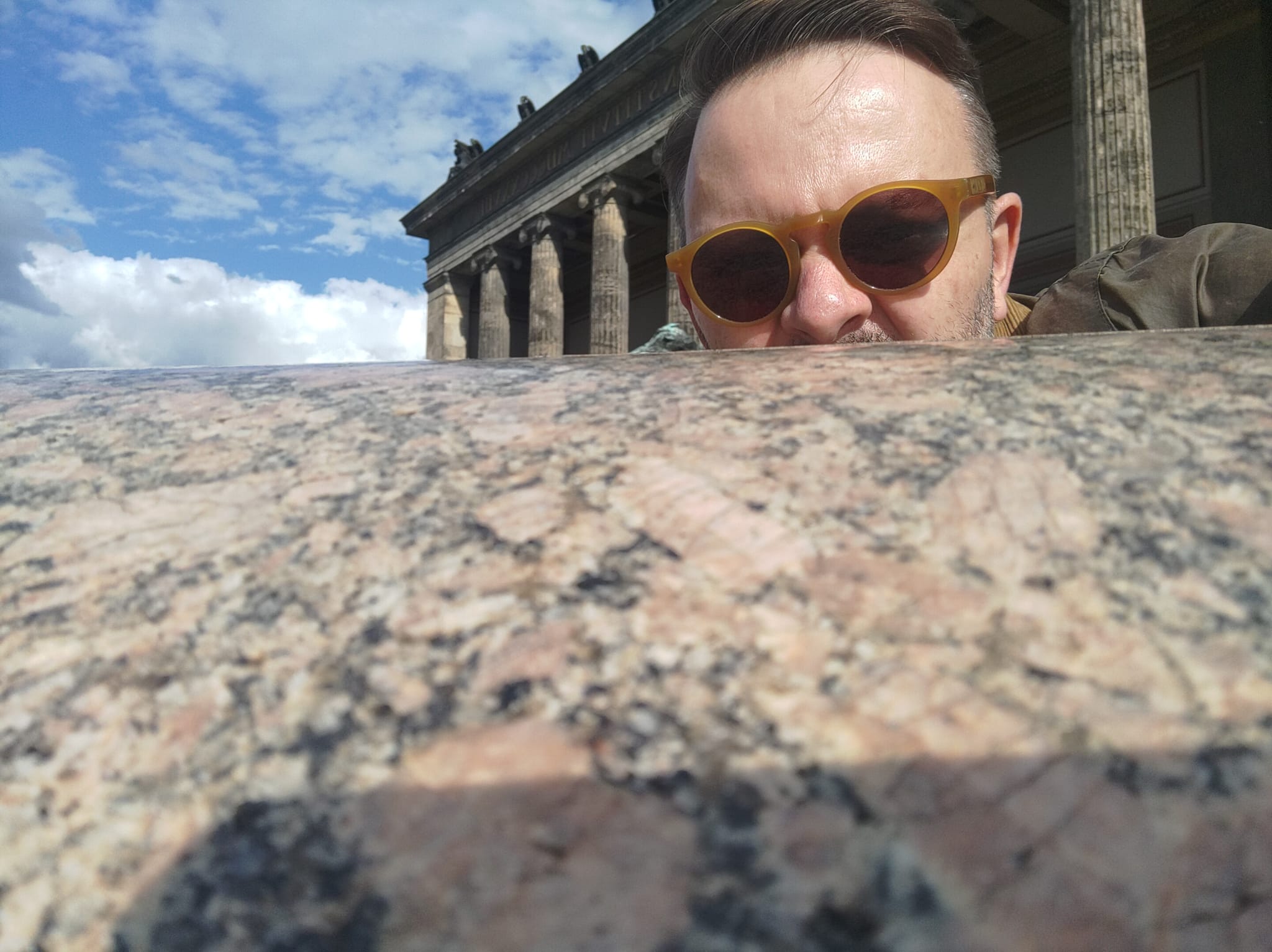 Sven Lachhein mit Sonnenbrille, hinter einer steinernen Schale vor einem Säulengebäude
